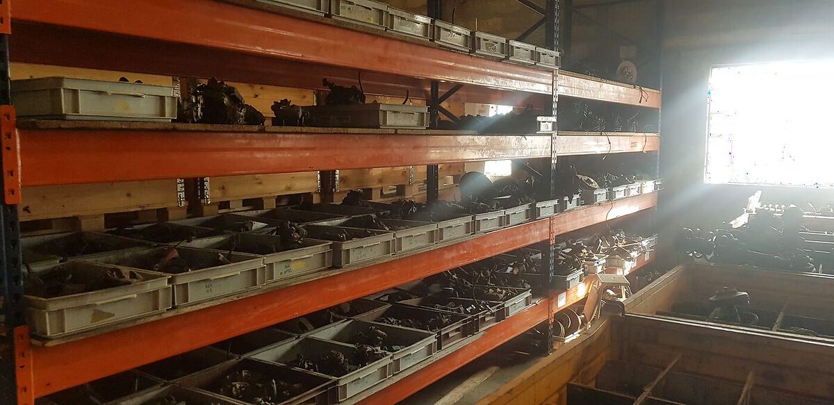Rayonnages orange chargés de bacs de pièces mécaniques dans l'entrepôt